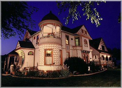 A large white house with a tree in front of it.